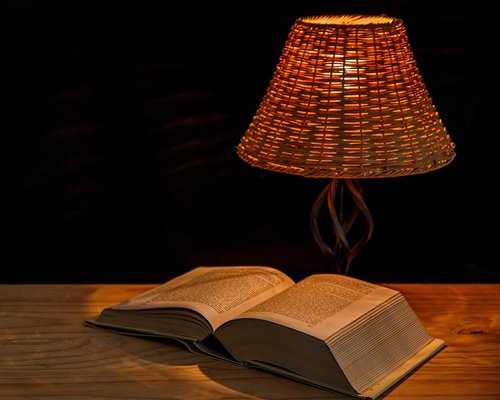 A relaxing bedroom interior with a warm glowing night lamp creating an ideal reading atmosphere